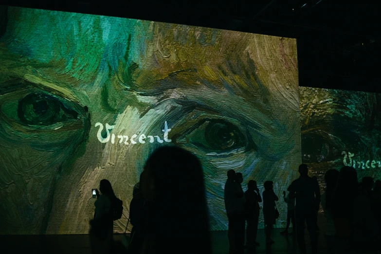 a group of people standing in front of a projection of an eye