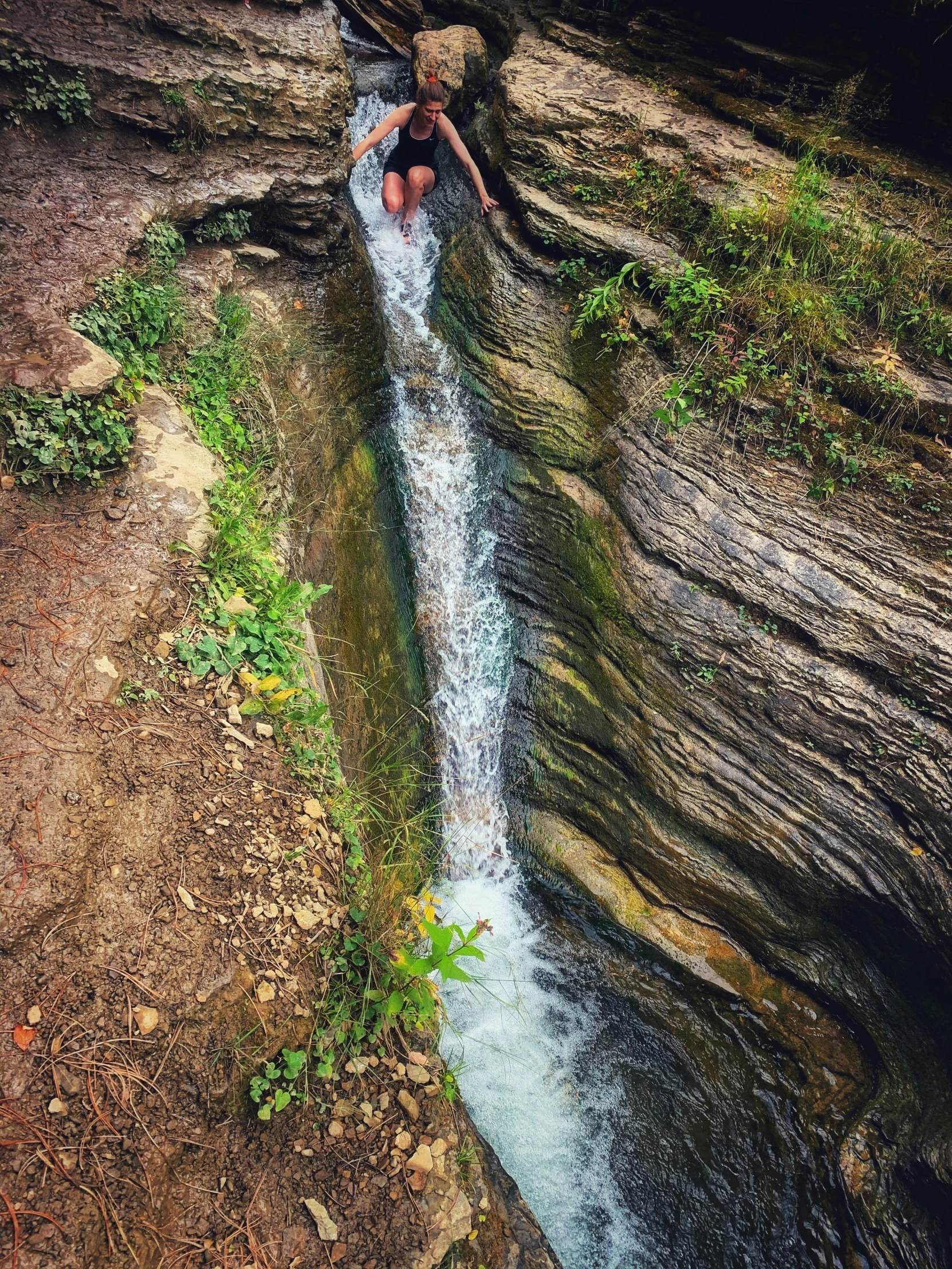 a woman hanging out at the bottom of a pool in a jungle