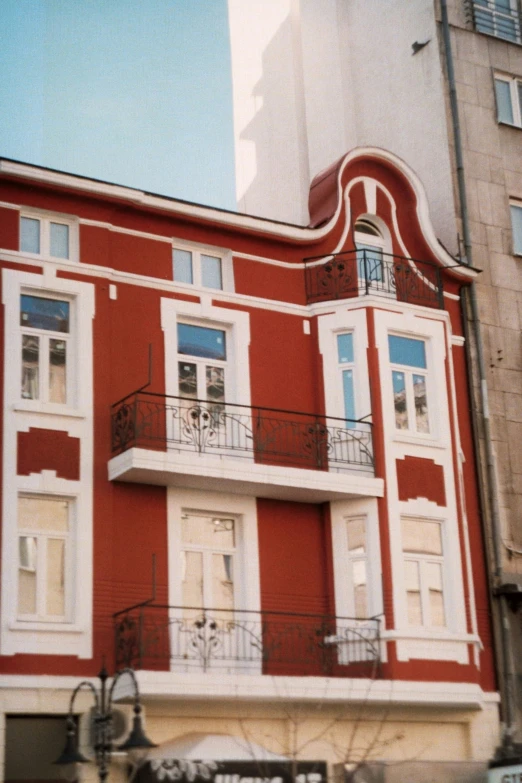 a tall red building with a balcony and balconies