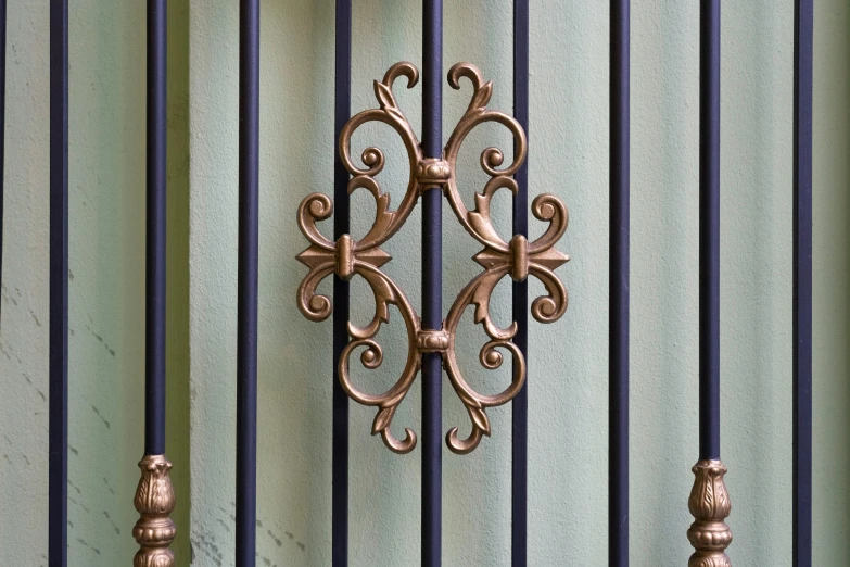 a clock mounted to a metal wall near some blue gates