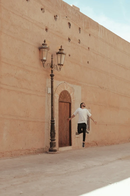 a man with a skateboard standing in front of a brown building