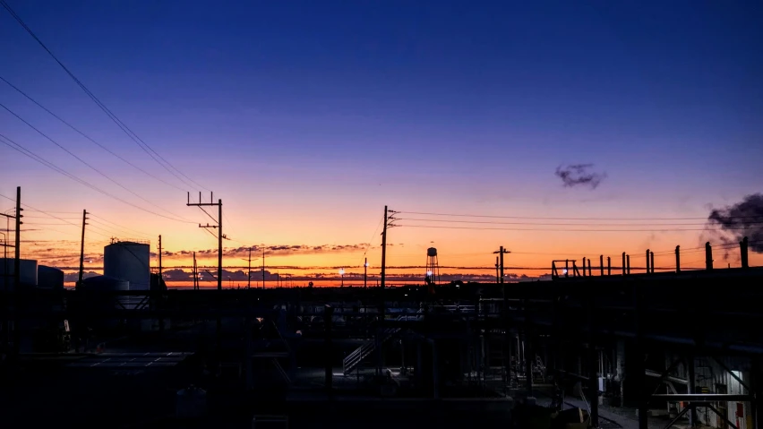 an electrical plant at dusk as the sun sets