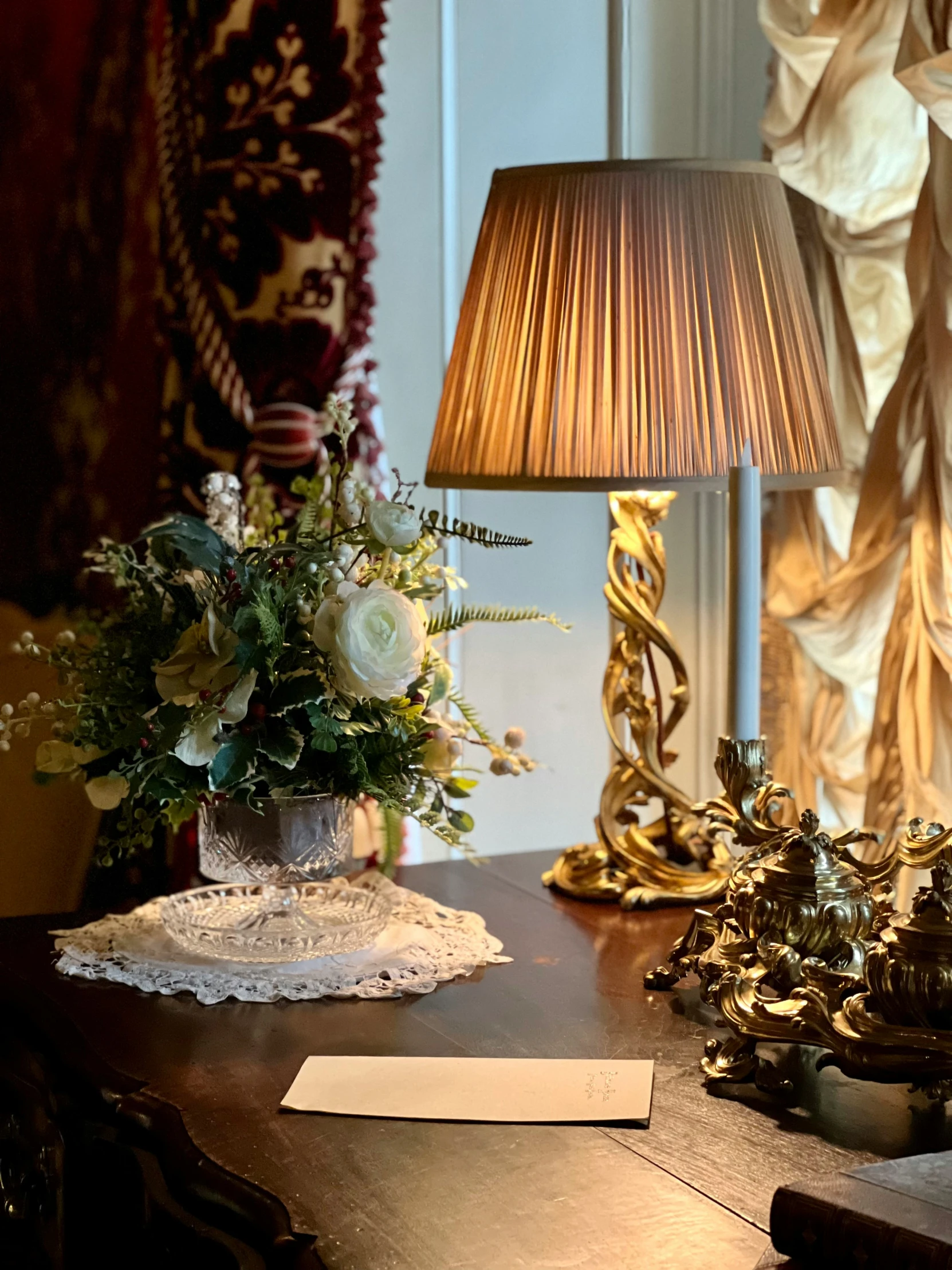 flowers sitting on a desk with a lamp