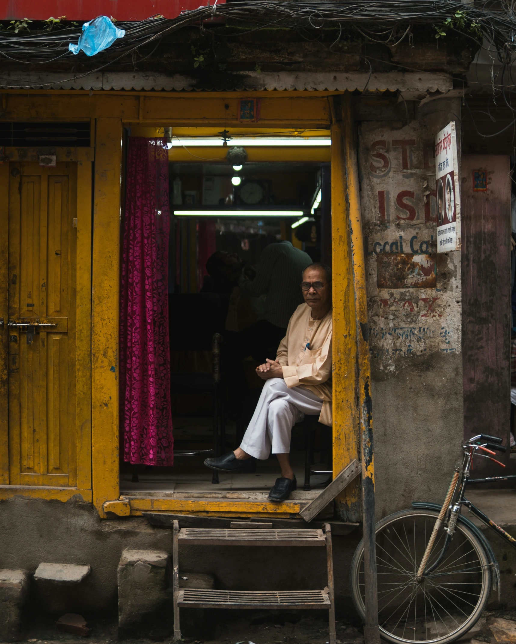 the man is sitting inside his small room