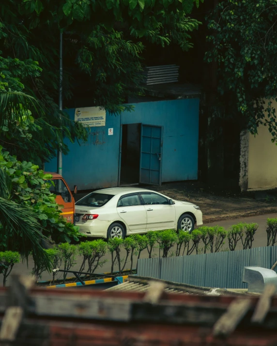 a white car is parked by a fence