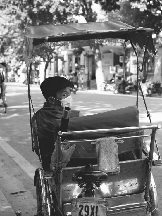 an indian man sitting in the back of a cart with two baskets on it