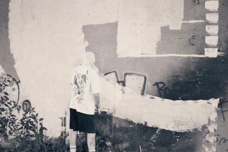 a boy standing in front of a white wall