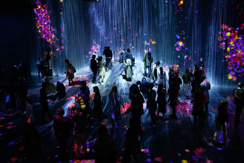 a group of people standing under colorful lights