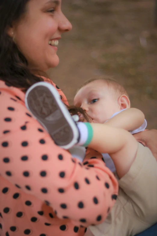 the woman is holding the baby and smiling