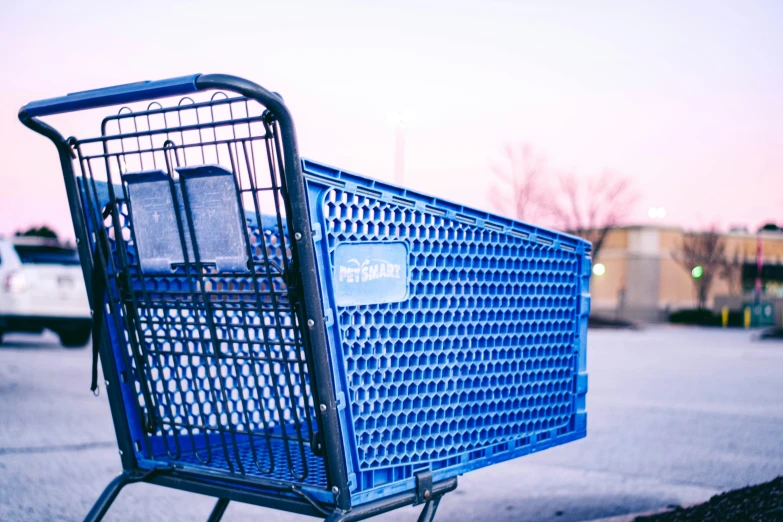 an empty shopping cart on the sidewalk with buildings in the background