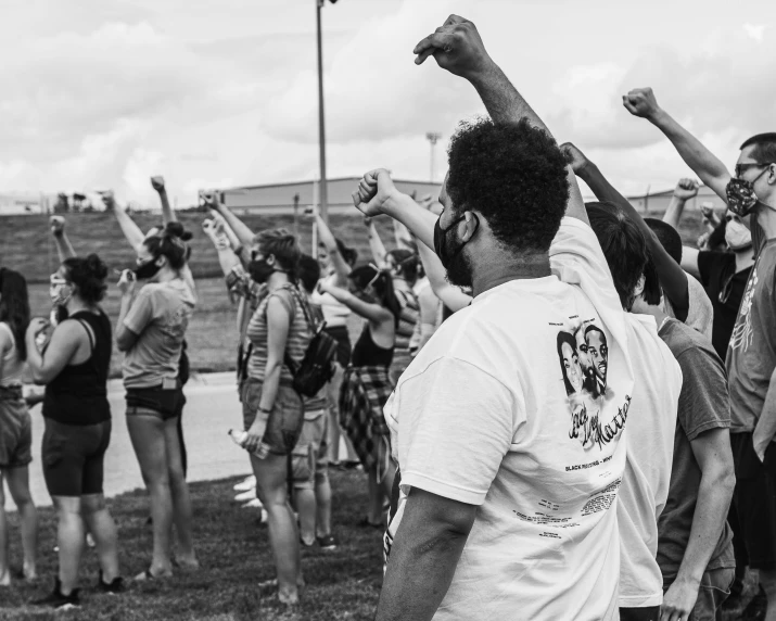 a group of people in a field are holding up their arms