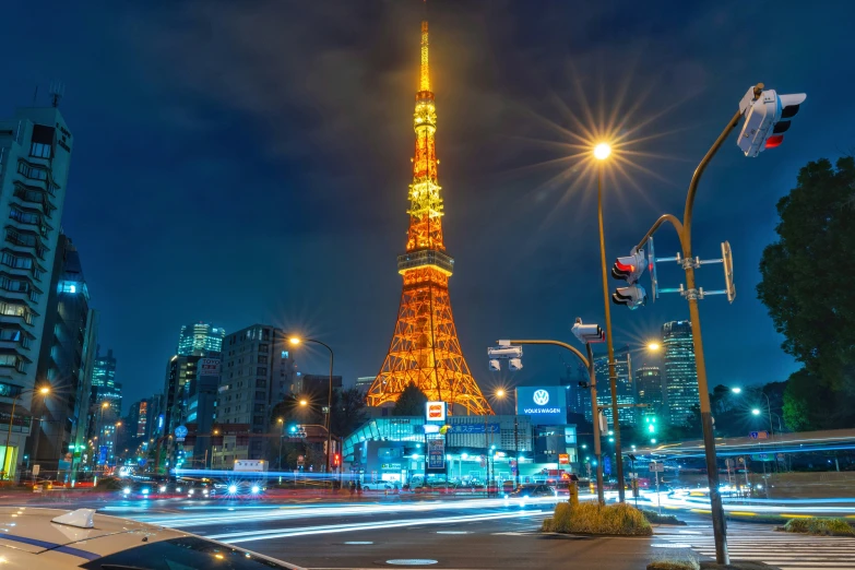 a very tall tower next to some buildings at night