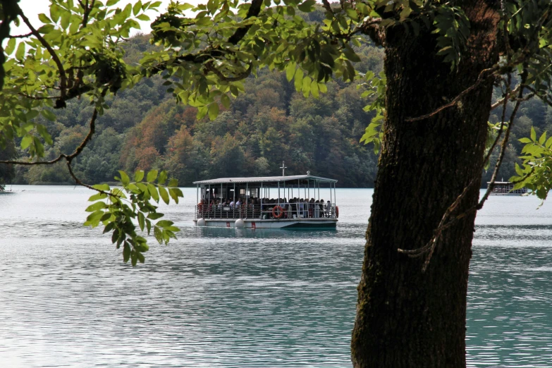 a boat sailing through a beautiful lake surrounded by trees