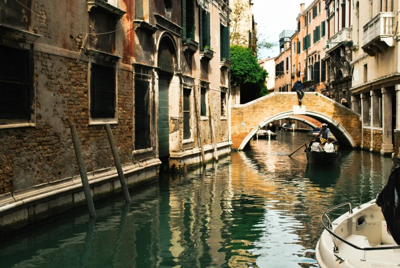 the man is rowing his small boat through a canal