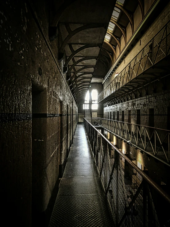 a dimly lit hallway leading to several stalls