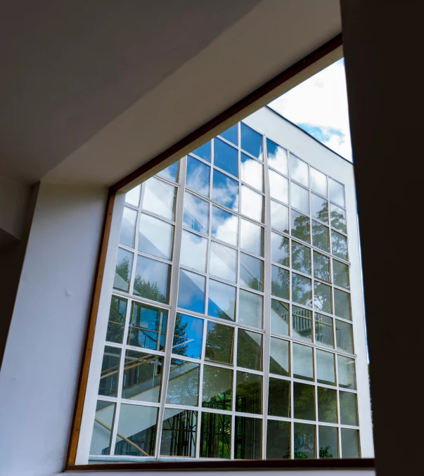 a view outside of a glass window with a blue sky in the background