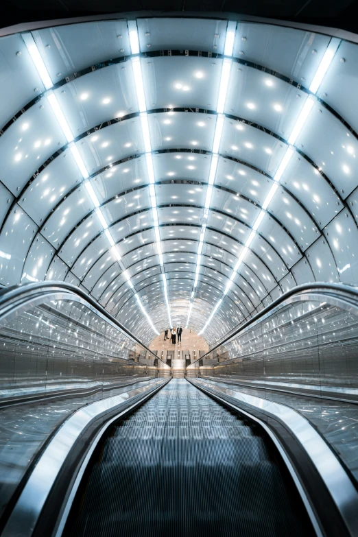 view of an escalator with people walking through it at night