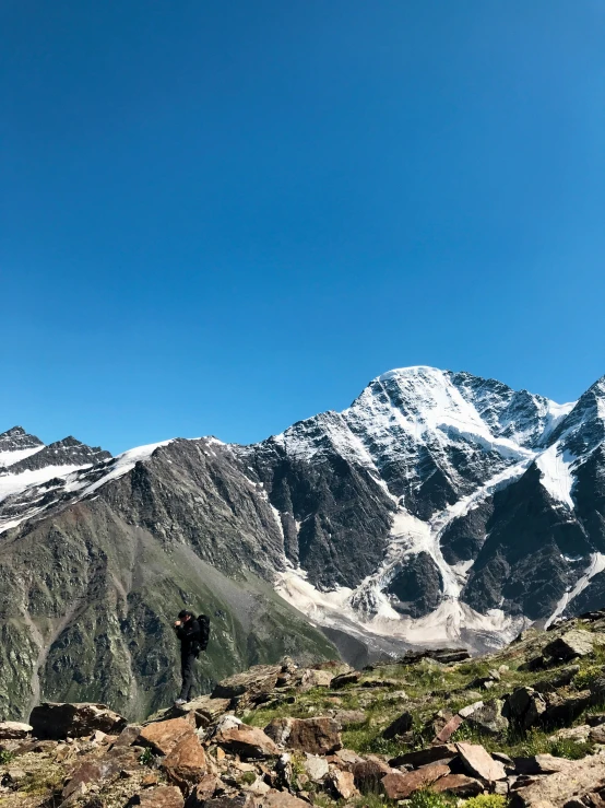 two people are standing in the mountains above