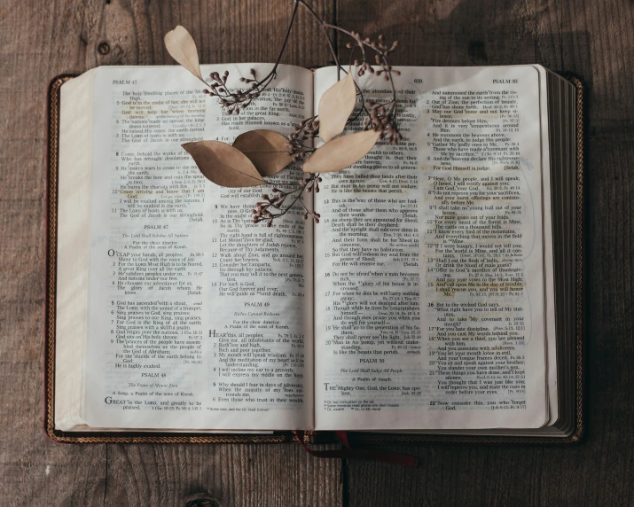 an open book on a wooden surface with some paper