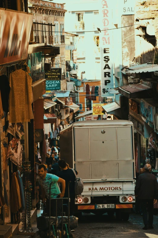 the trucks and pedestrians travel down the crowded street