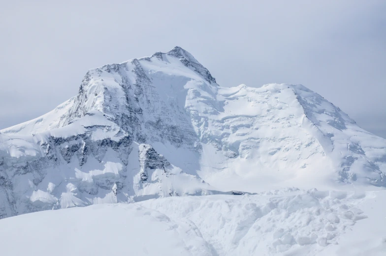 a mountain of snow covered with clouds in the day