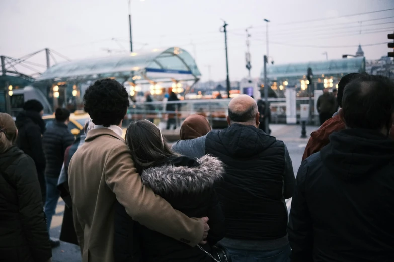 a group of people are standing on the sidewalk