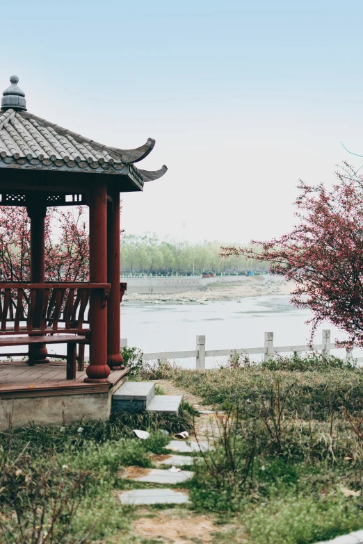 a gazebo sits in front of a body of water