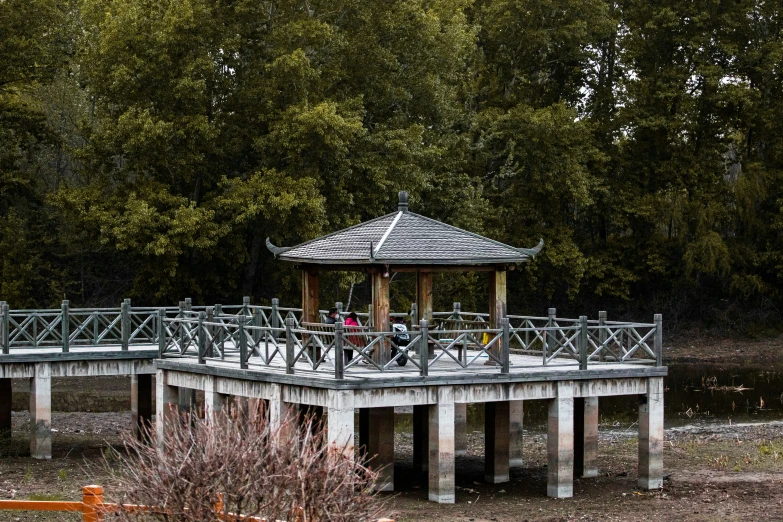 a boardwalk with benches leading to a gazebo