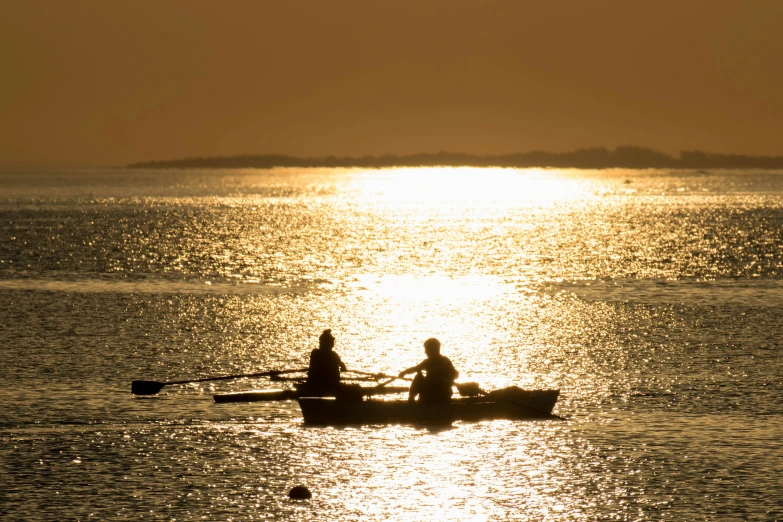 two people in a boat and a dog on the beach