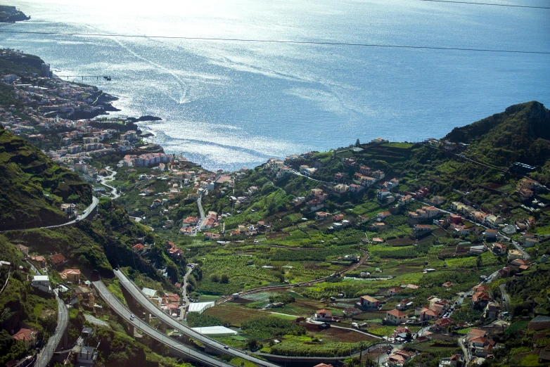 a hill with lots of greenery and small houses on top of it