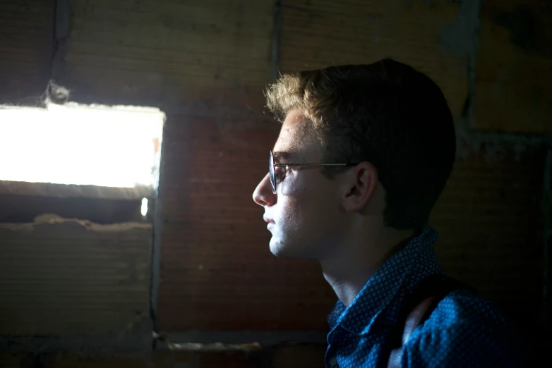 a man with dark glasses, blue shirt, and red tie