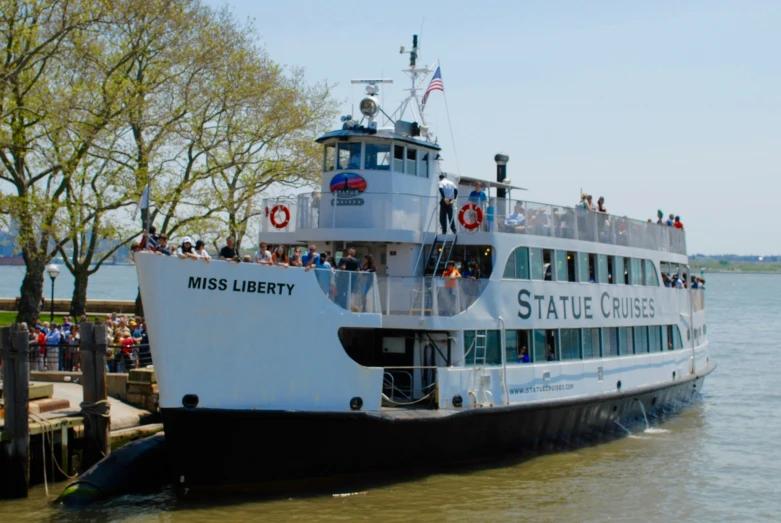 a boat with several passengers is docked near a harbor