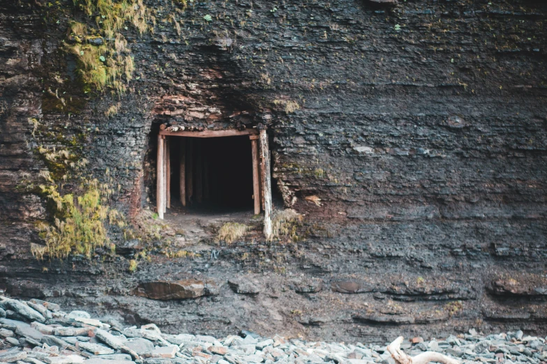 an old and weathered looking rock wall with a small tunnel