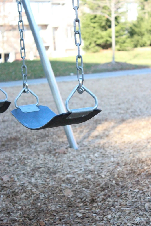 a swing in a children's playground with an arm extended for people to use