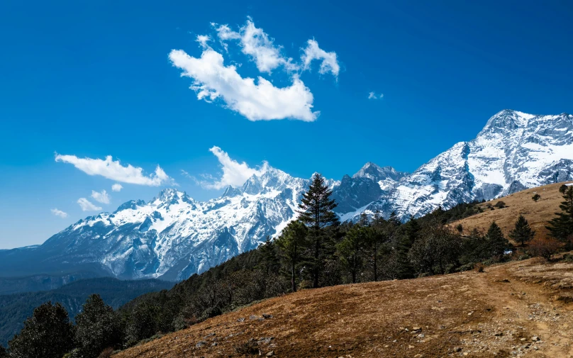 a group of clouds are high over the mountains