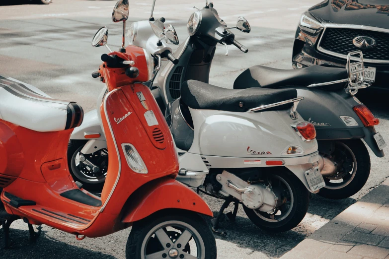 motor scooters are parked on the sidewalk near the street