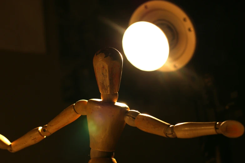 there is a wooden dummy in front of a light