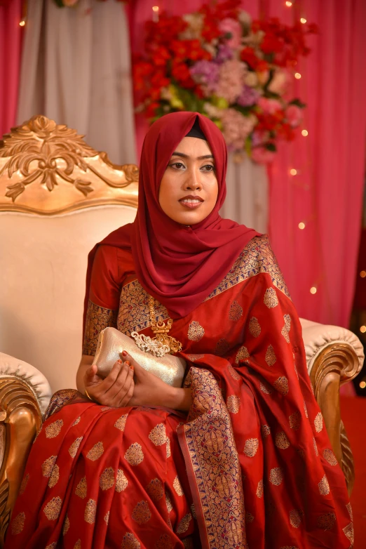 a woman sitting in a chair holding a clutch