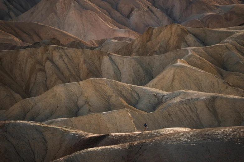 a landscape of mountains, a man with a camera and some people