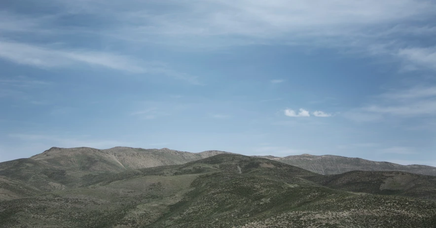 a airplane is flying in the sky over mountains