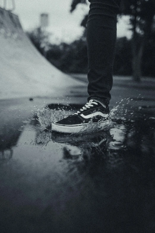 the foot of a person on a skateboard in the rain