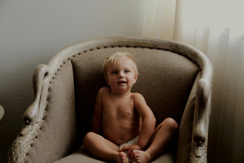 a  baby sitting in a chair with sun shining through the window