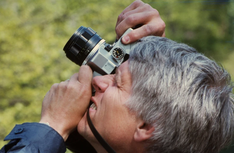 a man holding a camera up to his face