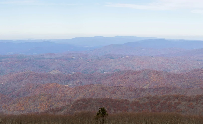 the view of some mountains, with a distant forest below