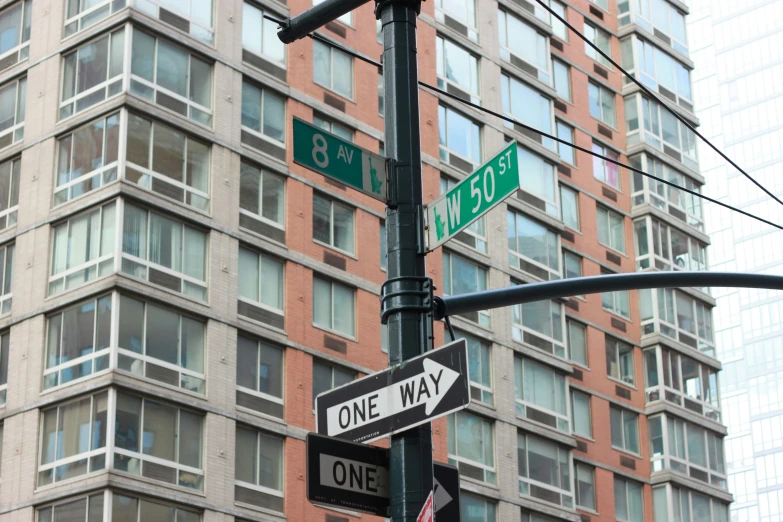 three street signs are posted next to a building