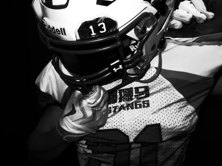 a football player wearing a helmet, gloves and head gear