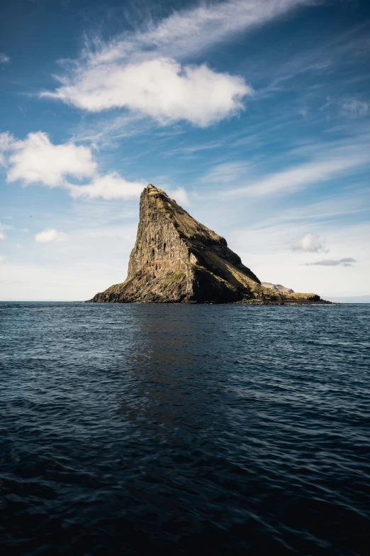 a lone rock in the middle of water