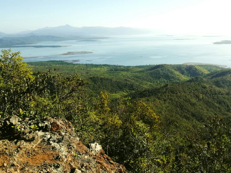 an scenic view of a large body of water surrounded by lush green hills