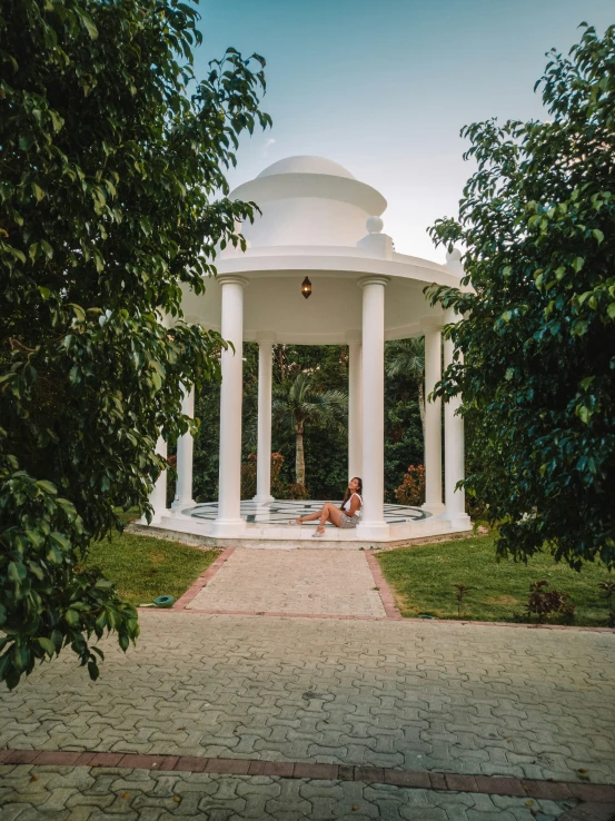 a gazebo sitting on top of a park next to trees