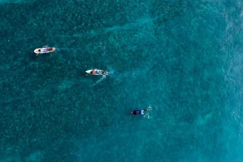 three boats in the ocean on a sunny day